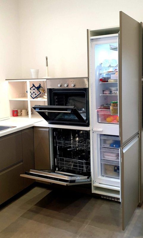 Piano di lavoro IKEA inserito tra forno e lavastoviglie per supporto e integrazione nella colonna frigo.